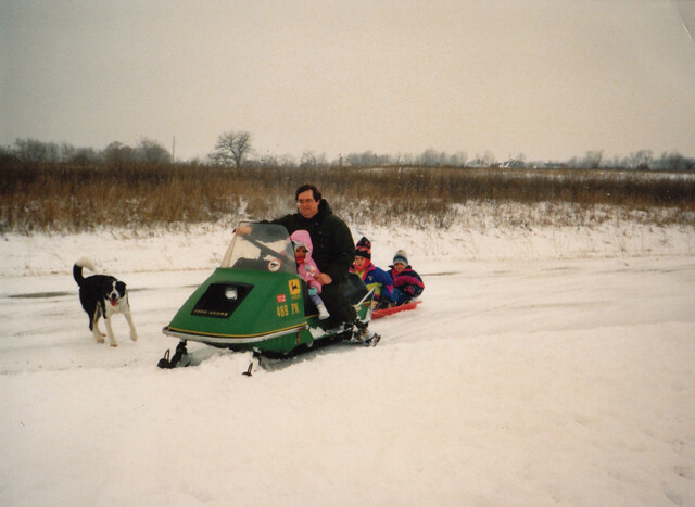 V1 Managing Editor Trevor Kupfer and his brother ride in a sled pulled by Dad’s snowmobile.