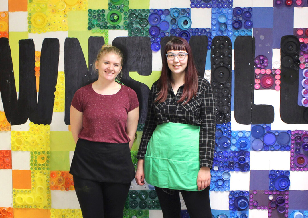 PUT A LID ON IT. Two UW-Stout art majors, Abby Henderson, left, and Grace Rogers, right, created a mural at Downsville Elementary School with the help of Downsville students and approximately 7,000 bottle caps.