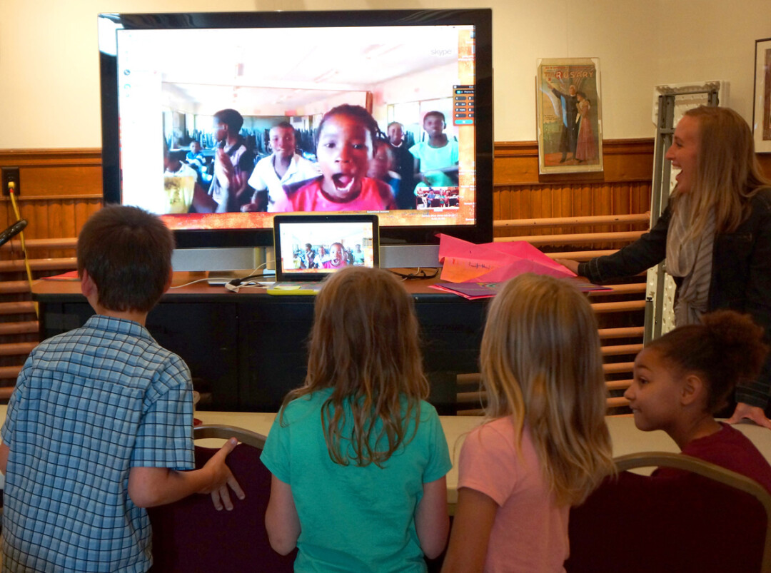 LONG-DISTANCE CONNECTION. Menomonie children connect with children in Botswana via Skype during a PAINT International art session at the Mabel Tainter Center for the Arts. At right is Megan Steinkraus, PAINT coordinator, Menomonie elementary art teacher and UW-Stout alumna. 