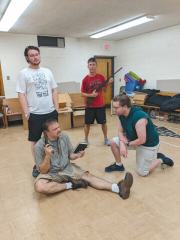 GUNNING FOR INFAMY. Cast members rehearse 