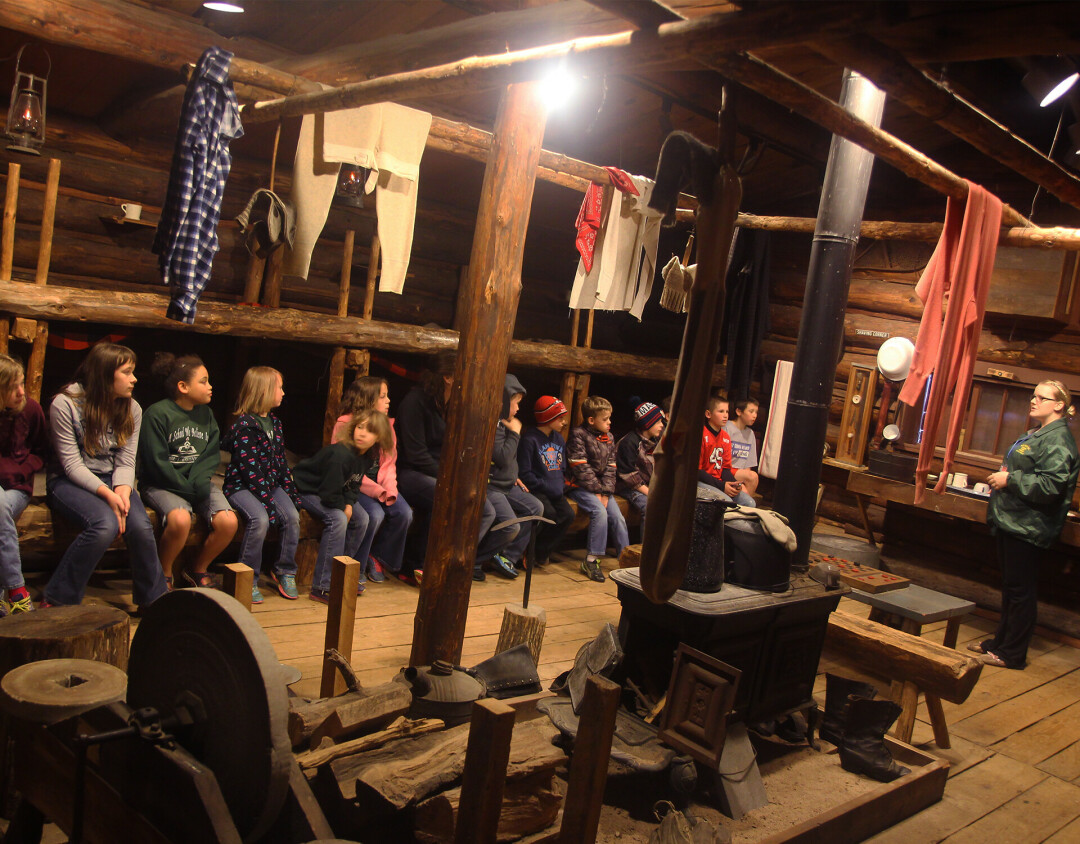 LEARNING ABOUT LOGGING. Kids learn about Wisconsin's logging history in the bunkhouse at the Wisconsin Logging Museum.
