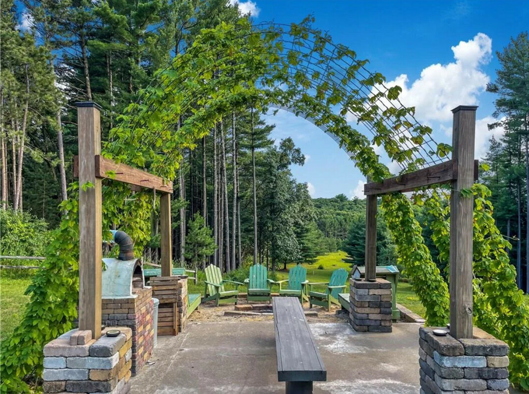 GET A PIZZA THIS. You can own the whole dang pie – and the wood-fired pizza stove with terrace – with this home. (Photos via Zillow)