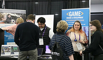 Attendees at the M+DEV game conference in Madison visit the UW-Stout booth.