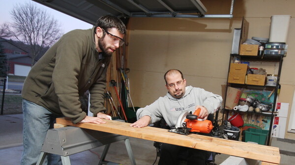 Taking time to cut the line. Jason Endres (right) fills Zacharious Pappas’s (left) request for assistance with a wood working project. Both men are members of the Chippewa Valley Time Bank.