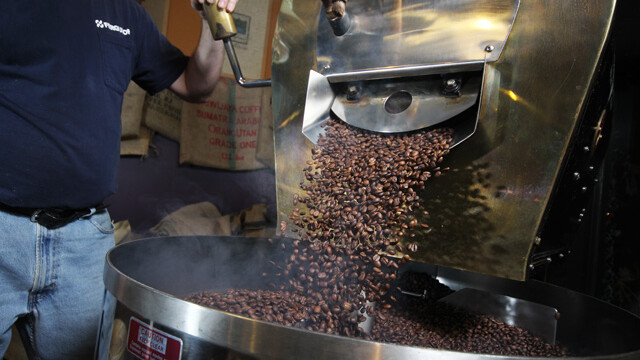 A roaster at Coffee Grounds prepares beans from the Farmer to Farmer program for brewing and drinking.