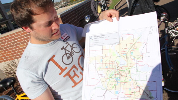 HE KNOWS THE WAY. Pedal evangelist Jeremy Gragert shows off a map of Chippewa Valley bike routes during a Bike to Work Week kickoff event outside the Volume One World Headquarters last spring.