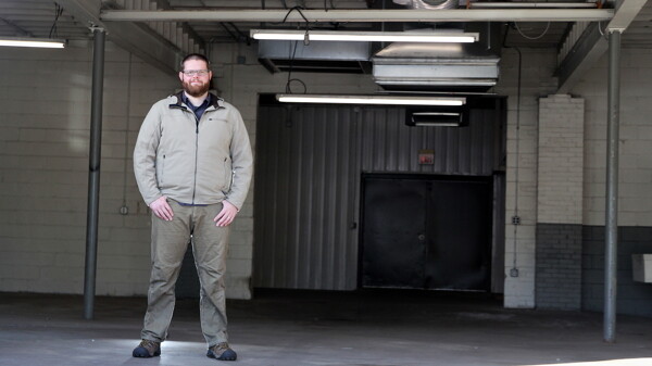 BIG AND UGLY (THE BUILDING, WE MEAN). Eau Claire Brewing Project’s owner and proprietor, Will Glass, stands in its big, empty, temporary space in Eau Claire’s West Bank.