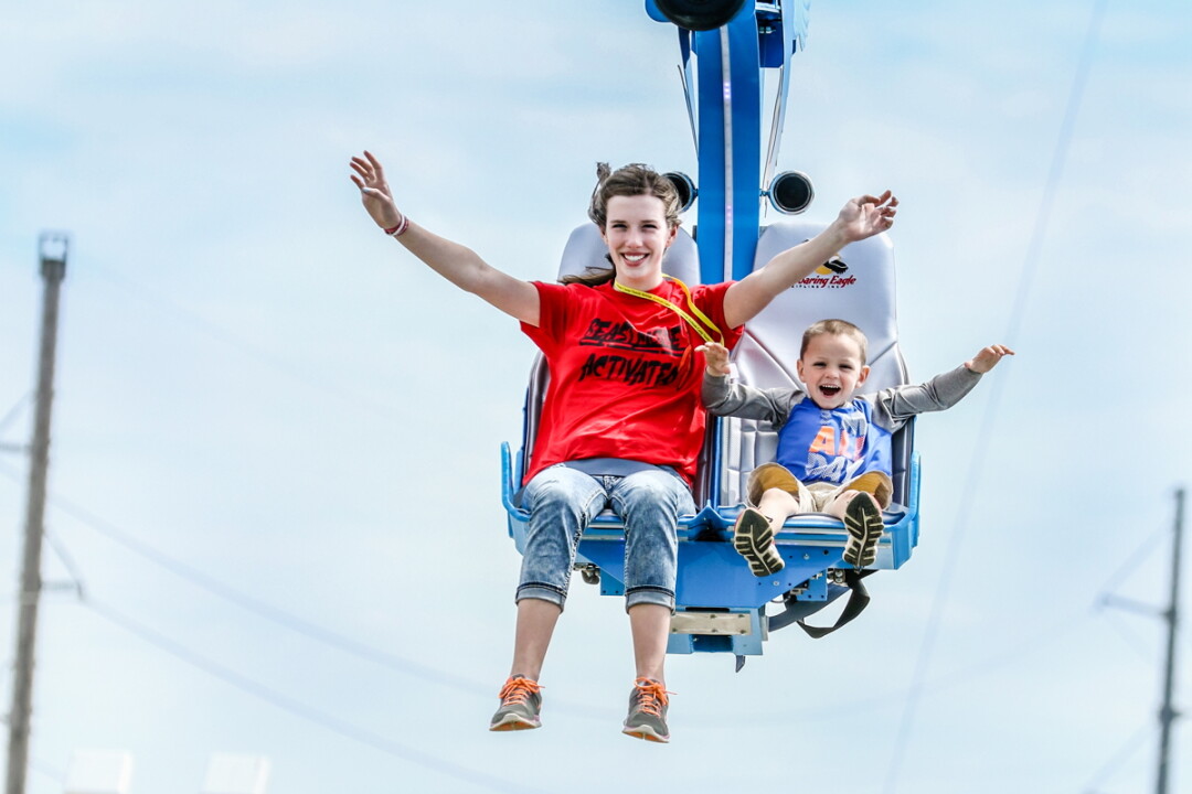 IT’S HIP TO ZIP. A pair of happy zip-liners try out the new motorized zip-line at Action City in Eau Claire. Open as of Saturday, May 6, the ride is 130 feet high and 700 feet long. The amusement center also opened up a new outdoor go-kart track on the same day.