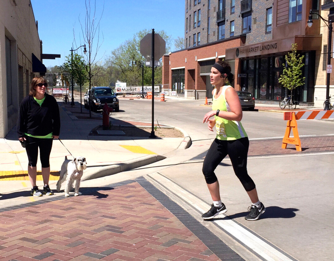madeline gray, right, runs in last month’s eau claire marathon as her mother, JANE, cheers her on.