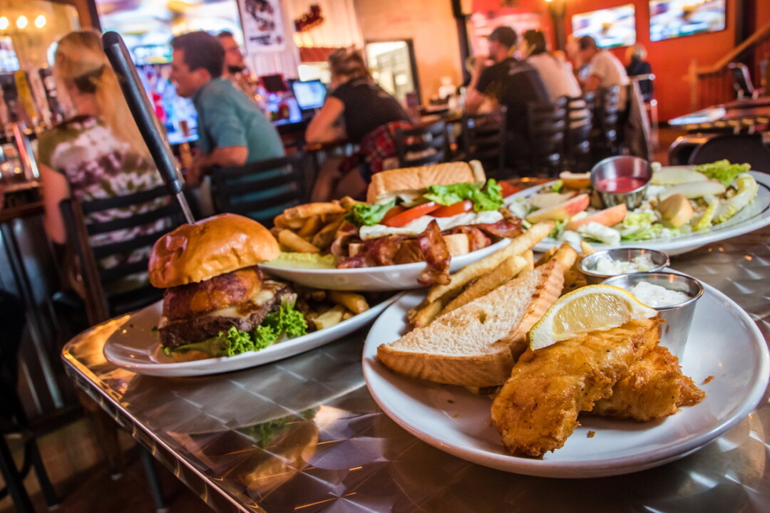ZONED FOR FLAVOR. The District (newly opened at 101 Graham Ave. in Eau Claire) offers up an array of robust burgers and sandwiches (such as the Farmhouse BLT, far right), many of them paired with a beer suggestion. 