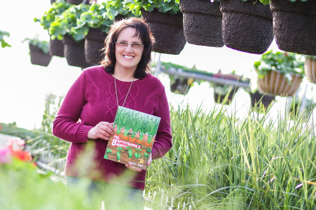 IN THE GARDEN. Carol Awe, author of Ms. Greenthumb’s Garden, shows off her debut story among greenery.