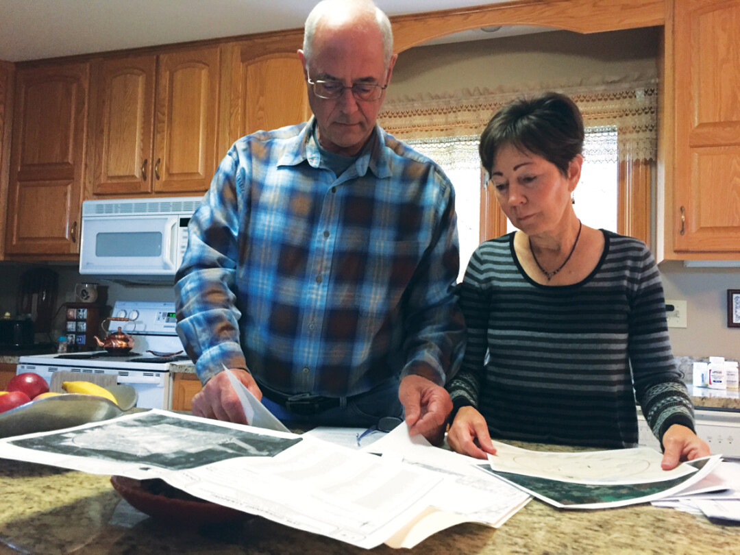 Dennis and Kathy Campbell look at paperwork related to the proposed expansion of the landfill, which is about half a mile from their house.