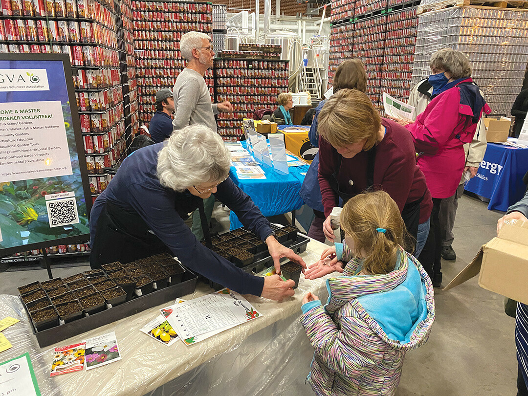 Volunteers from the Eau Claire Area Master Gardeners Volunteer Association help an event attendee choose their seeds to plant in a portable planter. Returning organizers will introduce their sustainability initiatives at the open house through all-ages activities. 