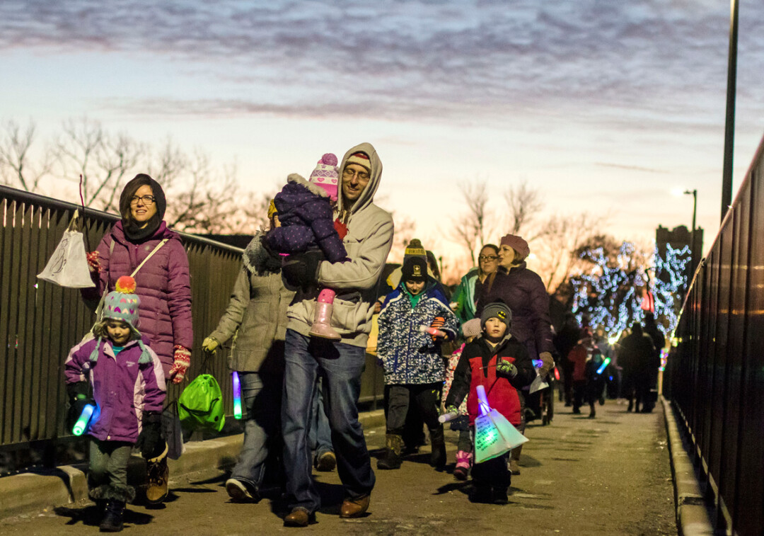 On New Year's Eve, families take to the Grand Ave. walking bridge in downtown Eau Claire carrying homemade paper lanterns.