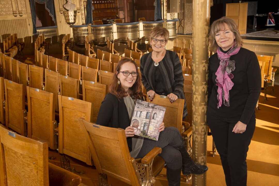 illustrator Taylor Kysely, board member Judy Foust, and author Mary Heimstead created a book set at the Mabel Tainter Theater.