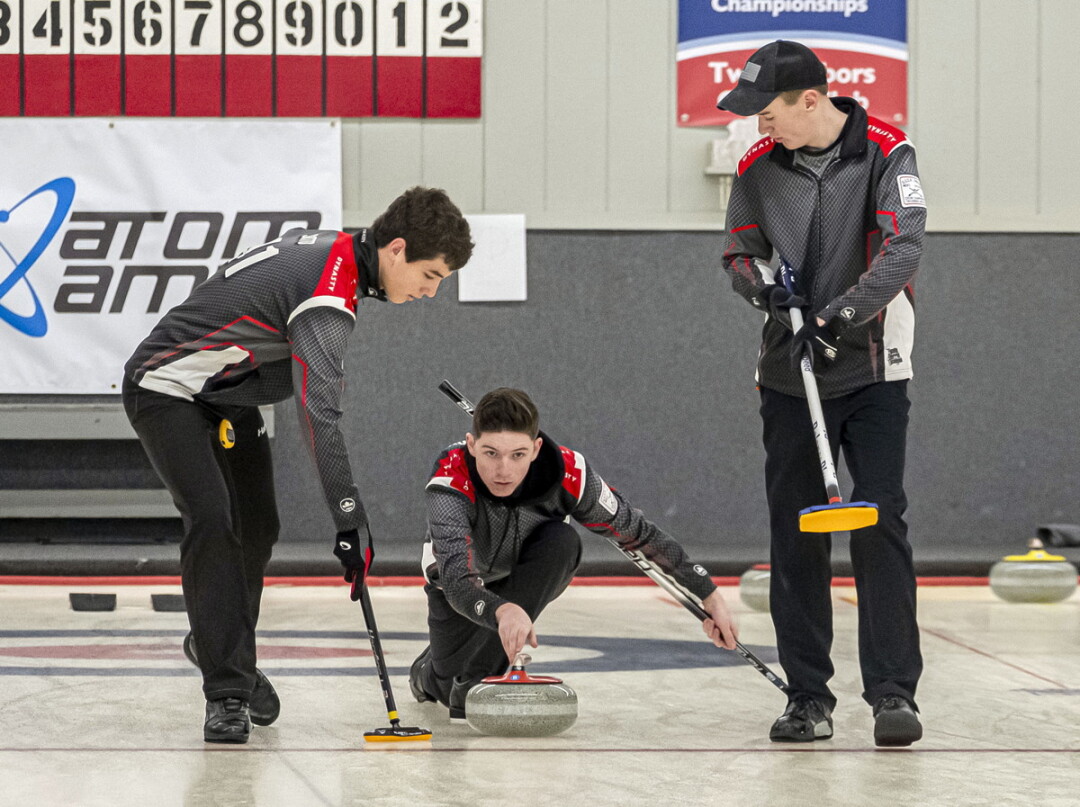 Charlie Thompson (center) delivers the rock during last year’s junior national championships in Two Harbors, Minnesota.